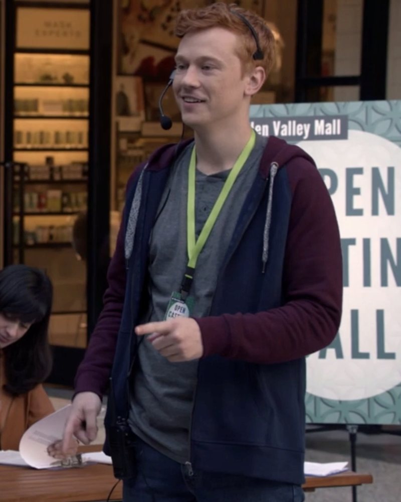 Kevin in a headset and lanyard at a mall open-casting table